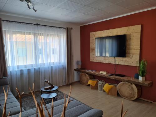 a living room with a flat screen tv on a wall at Sweet Home Ferienwohnung in Ruderatshofen