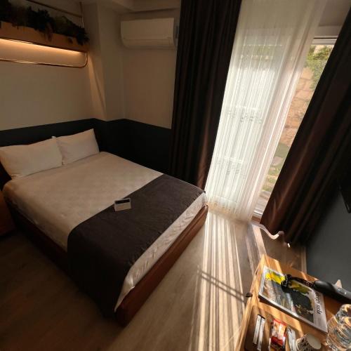 a bedroom with a bed next to a window at Urla 1867 Hotel in Urla