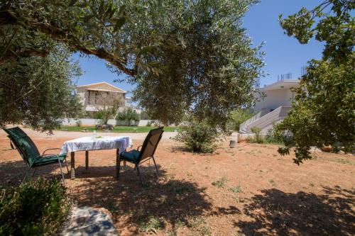 a table and chairs under a tree in a yard at Casa Magnolia in Kathiana