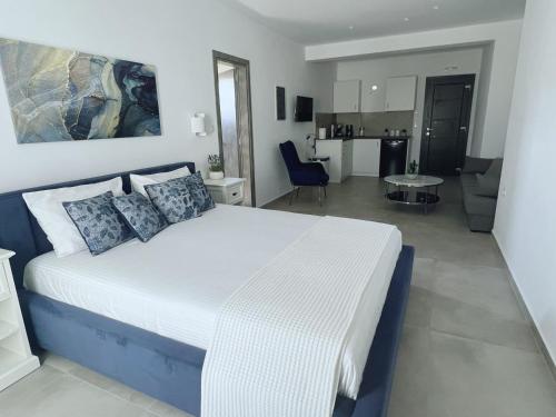 a bedroom with a large bed and a living room at All Blue Suites in Ambelas