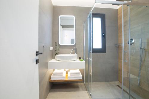a bathroom with a sink and a shower at Elianthi Luxury Apartments in Nikiana