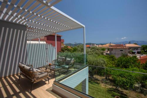a patio with a table and chairs on a balcony at Elianthi Luxury Apartments in Nikiana