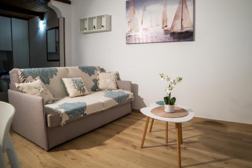 a living room with a couch and a table at Meraki House in Alghero