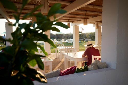 a man sitting at a table on a patio at Montiro' Hotel in Leuca