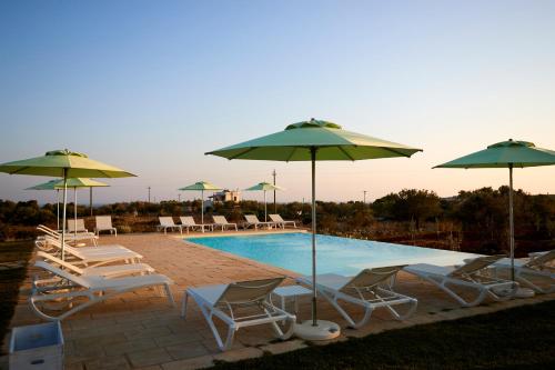 a group of chairs and umbrellas next to a pool at Montiro' Hotel in Leuca