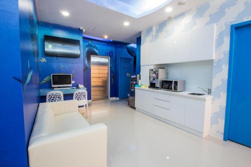 台北的住宿－清翼居旅店-海洋館，客厅配有白色沙发和蓝色的墙壁
