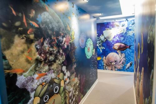 a room with a wall covered in different types of fish at Morwing Hotel - Ocean in Taipei