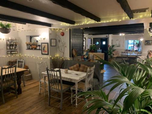 un ristorante con tavolo, sedie e divano di Molesworth Arms Pyworthy a Holsworthy