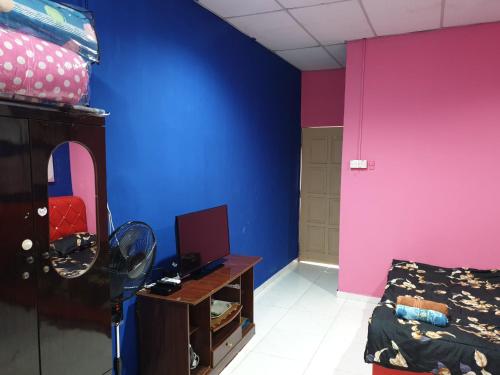 Cette chambre est dotée d'un mur bleu et rose. dans l'établissement InapDesa Studio Kangar Perlis, à Kangar