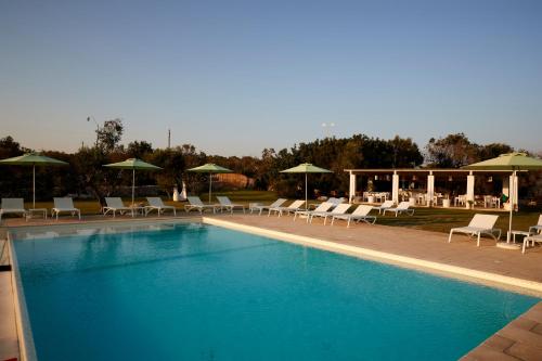 a swimming pool with chairs and umbrellas at Montiro' Hotel in Leuca