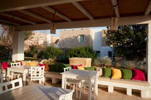 a patio with tables and chairs with colorful pillows at Montiro' Hotel in Leuca
