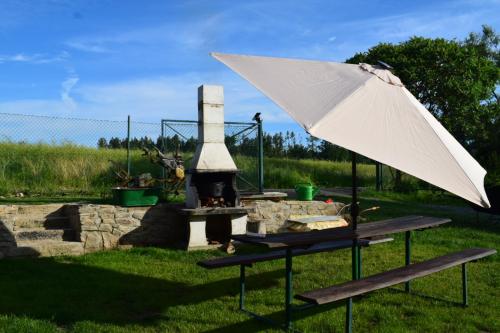 a picnic table with an umbrella and a grill at Kubátovna in Chotěboř