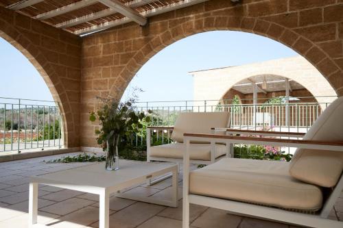 a patio with two chairs and a table at Montiro' Hotel in Leuca