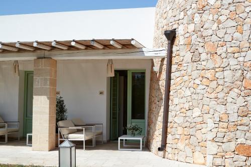 a stone wall with a pergola on a patio at Montiro' Hotel in Leuca