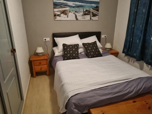 a bedroom with a bed with two night stands and two lamps at Taylors Camposol Apartment in Mazarrón