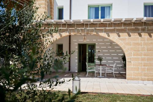 a patio with a table and chairs under a brick wall at Montiro' Hotel in Leuca