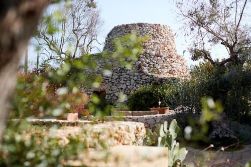 a stone tower in the middle of a garden at Montiro' Hotel in Leuca
