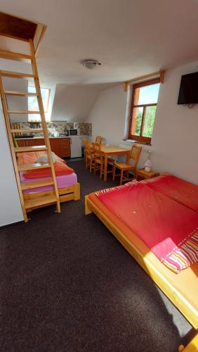 a bedroom with two bunk beds and a table and chairs at Kubátovna in Chotěboř