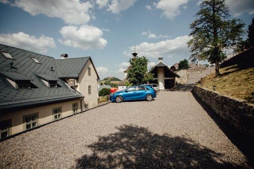 a blue car parked in front of a house at Hotel Glaus in Banská Štiavnica