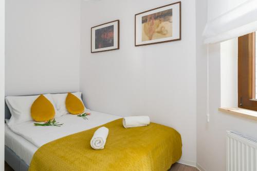 a bedroom with a bed with a yellow blanket at Apartment Kamienica Chełmońskiego 10 przy MTP in Poznań