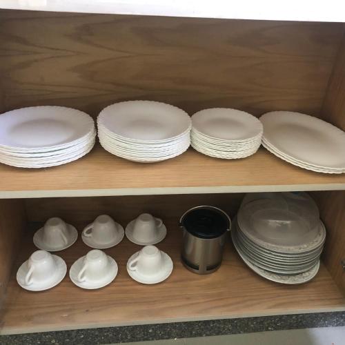 a shelf filled with white plates and dishes at Lovely penthouse 4- bedroom directly on the lagoon in El Alamein