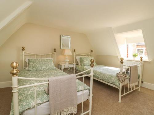 a attic bedroom with two beds and a window at Audleby in Market Rasen