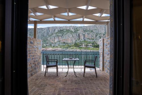 a patio with two chairs and a table with a view at Guesthouse Laoula in Gerolimenas