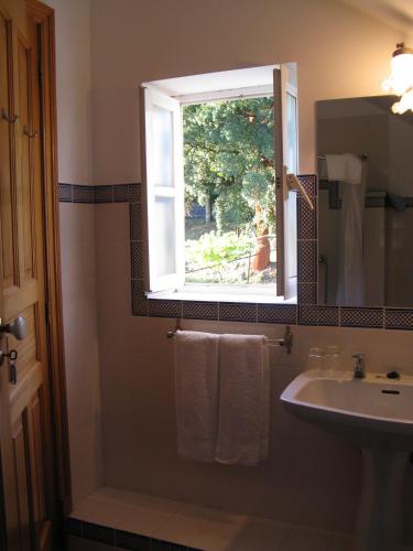 a bathroom with a sink and a window at Vila Guiomar - Casa da Eira in Alvarenga