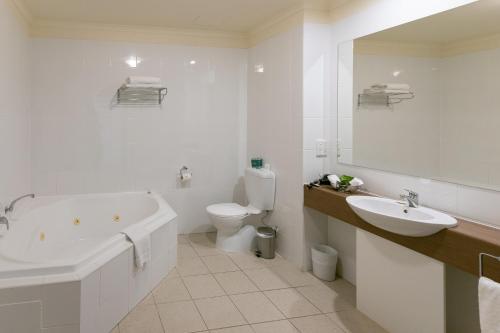 Lady Bay Hotel في نورمانفيل: حمام مع حوض ومغسلة ومرحاض