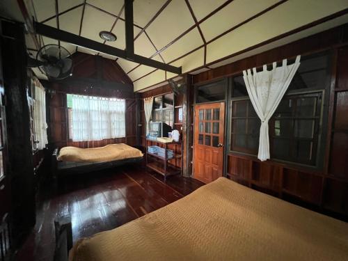 a bedroom with two beds and a window at ไร่นุชชม รีสอร์ทเขาค้อ in Ban Non Na Yao