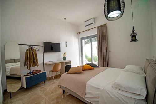 Schlafzimmer mit einem Bett, einem Schreibtisch und einem TV in der Unterkunft Villa Barone in Procida