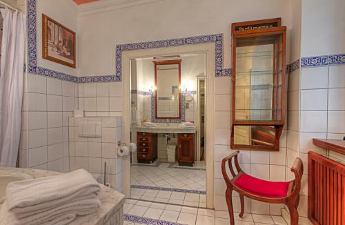 y baño con ducha, silla y lavamanos. en Hotel Orphée - Kleines Haus, en Regensburg