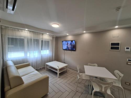 a living room with a couch and a table and a tv at Nero D'Avorio Apartments in Rimini
