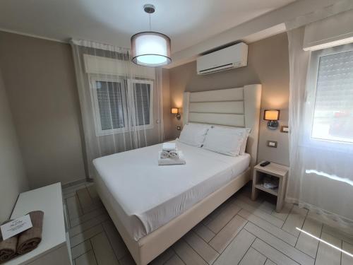 una camera con un letto bianco e una finestra di Nero D'Avorio Apartments a Rimini
