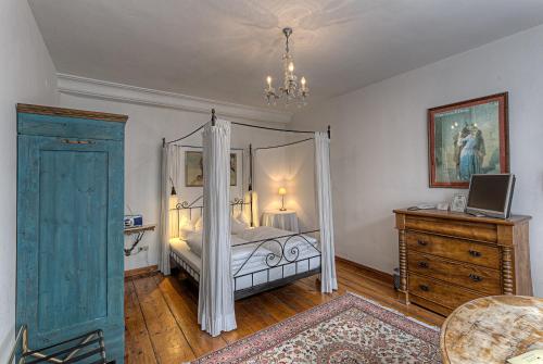 a bedroom with a canopy bed and a dresser at Hotel Orphée - Kleines Haus in Regensburg