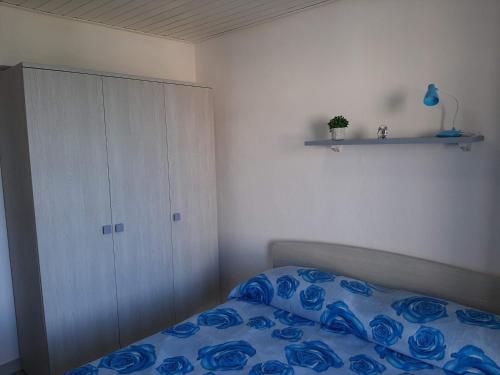 a bedroom with a bed with blue sheets and a cabinet at La Porta sul Mare in Pizzo