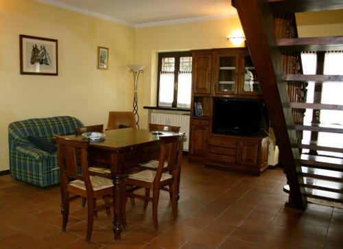 a living room with a table and chairs and a television at Ai Cappuccini in Racconigi