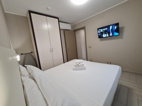 a white bed in a room with a mirror at Nero D'Avorio Apartments in Rimini