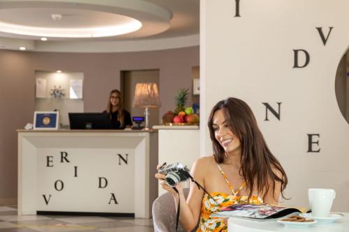 a woman taking a picture with a camera at Nero D'Avorio Apartments in Rimini