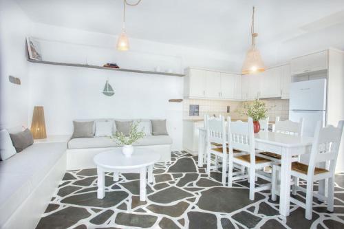 una sala de estar blanca con mesa y sillas en Penelope Villas, en Caristo