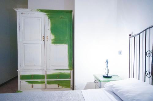 a bedroom with a green and white cabinet next to a bed at Albergo La Fontanella in Noto