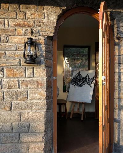 an archway leading into a room with a painting at Shantiniketan Mountain Home in Almora