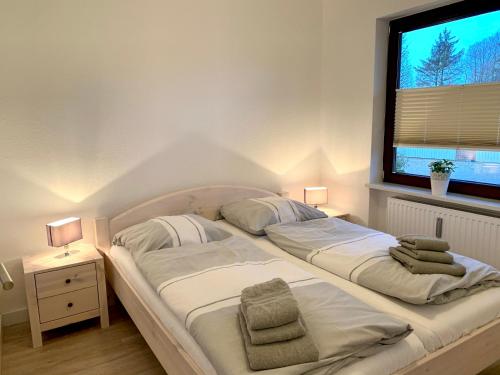 2 Betten in einem Schlafzimmer mit einem großen Fenster in der Unterkunft Ferienwohnung Seestern in Sankt Peter-Ording