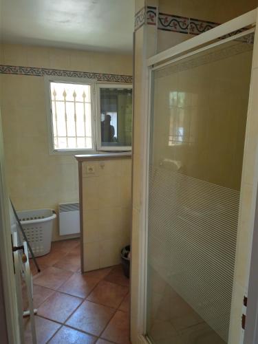 uma casa de banho com um chuveiro, um WC e uma janela. em Emilie em Vidauban