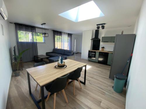 eine Küche und ein Wohnzimmer mit einem Tisch und Stühlen in der Unterkunft Maison vacance in Sainte-Soulle