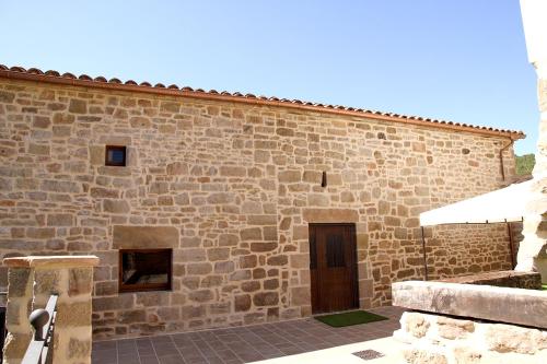 a large stone building with a door in the side at La Torreta d'Olius in Olíus