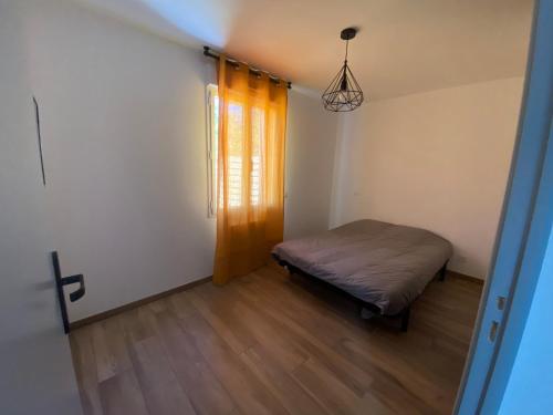 Kleines Zimmer mit einem Bett und einem Fenster in der Unterkunft Maison vacance in Sainte-Soulle