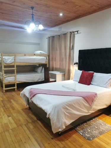 een slaapkamer met een bed en een stapelbed bij Sunrise Lodge in Kaapstad