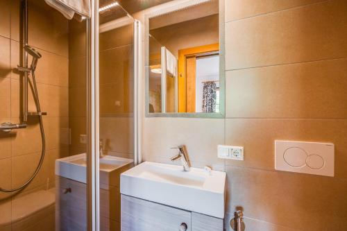 a bathroom with a sink and a mirror at Chaletdorf am Sonnenhang in Neukirchen am Großvenediger