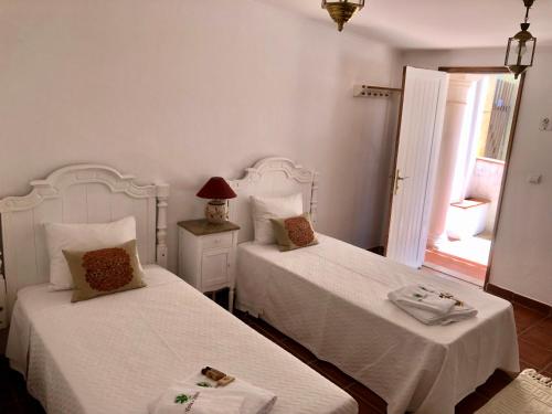a bedroom with two beds with white sheets and a window at Vinha da Quinta in Sintra